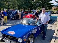 Brian Horan stands next to his antique British car for the DC British Reliability Run West Financial Services
