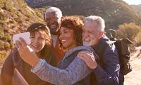 Four seniors taking a selfie in the mountains. West Financial Services.