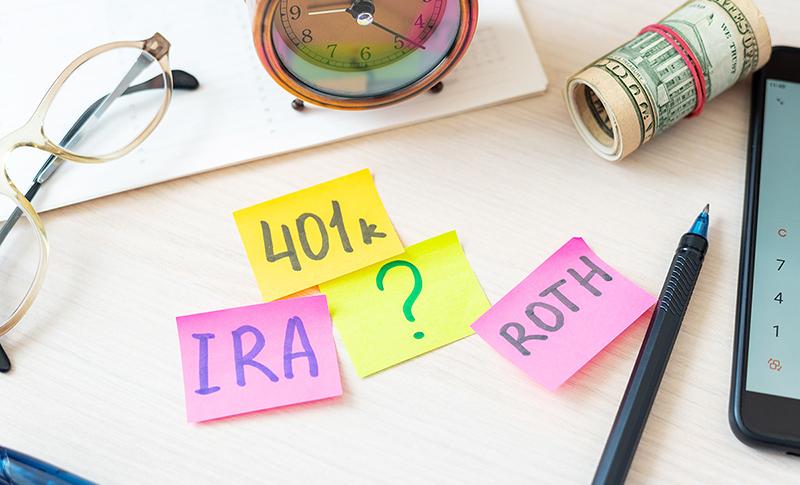 Sticky notes with 401k, IRA, ? , ROTH words. West Financial Services. 