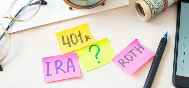 Desk with sticky notes that say 401k, IRA, ?, and ROTH. West Financial Services.